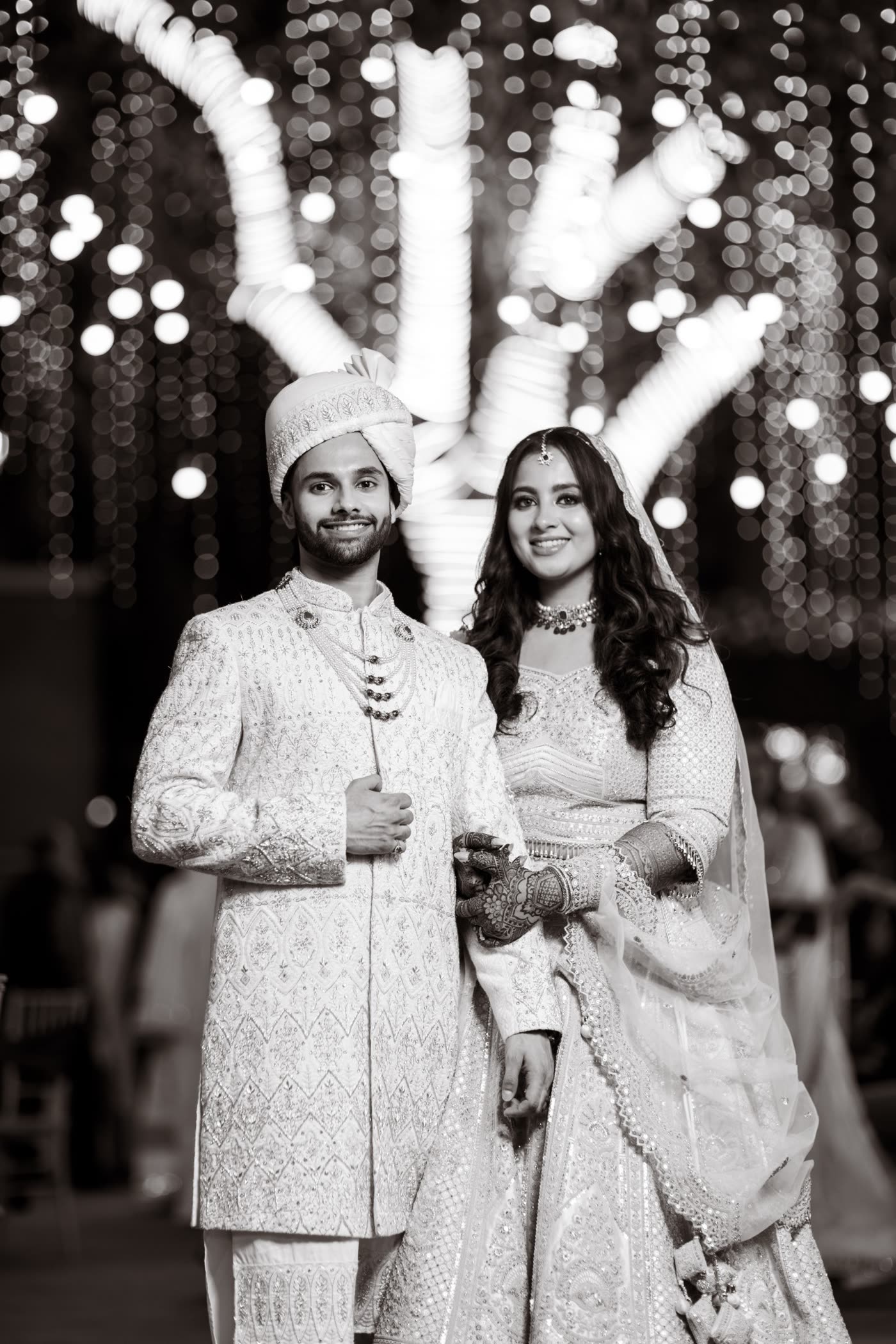 A couple beneath a lit tree, in black and white