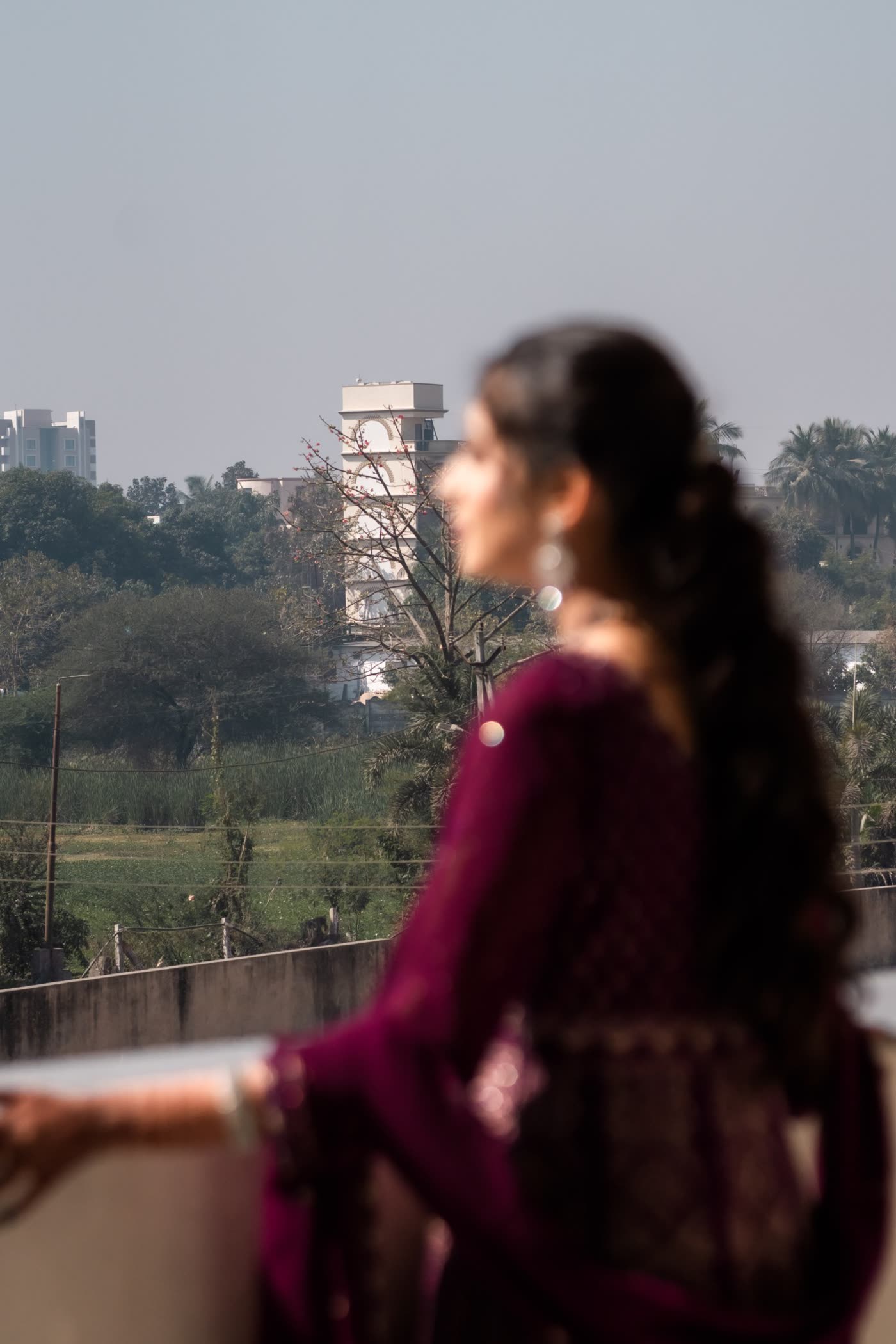 A bride looking out over the city at dusk