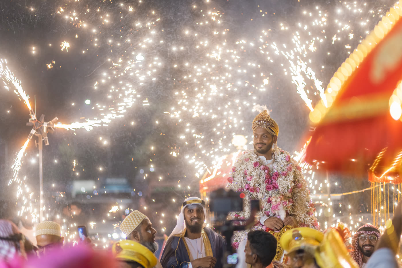 A baraat procession under fireworks at night